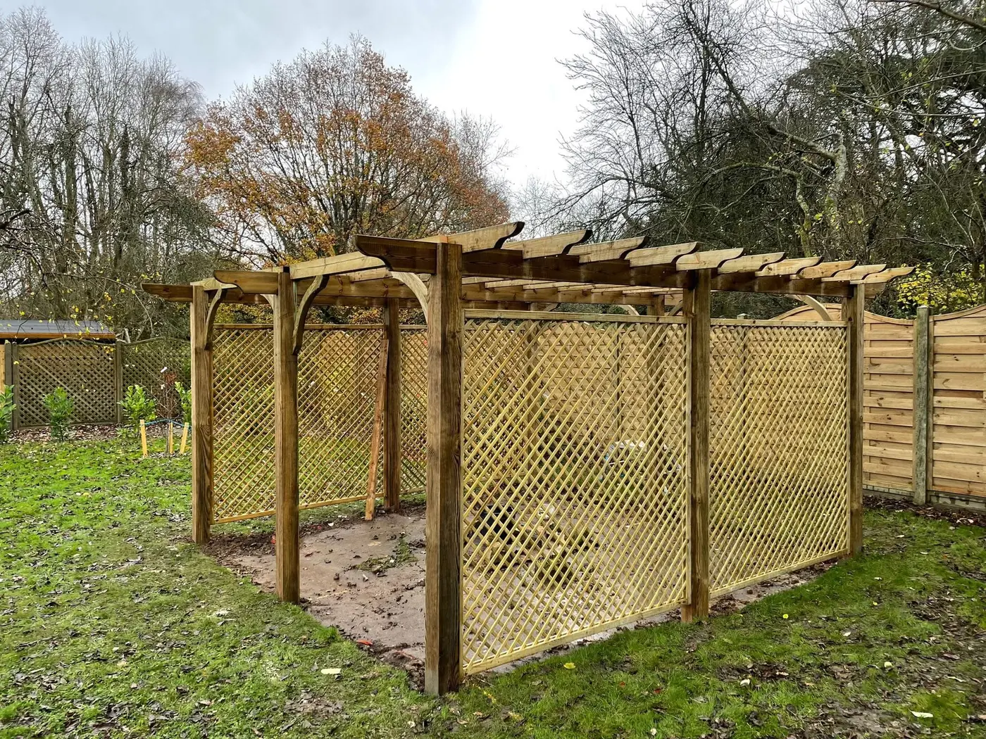 Timber pergola with diamond trellis screens on two sides, built by Tyrrells